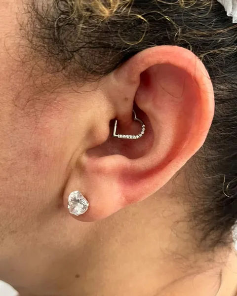 Orelha com piercing daith em formato de coração e brinco de pedra no lóbulo